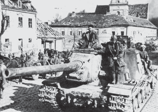 Cazacarros SU-152 e infantería en una población germana de Prusia Oriental. Enero de 1945