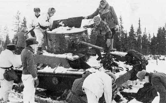 Soldados fineses inspeccionando un tanque soviético T-26 abandonado en la carretera de Raate. Enero de 1940