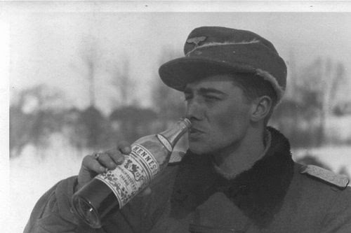 Peiper echando un trago de una botella de Hennessy, capturada a los americanos durante la batalla de las Ardenas